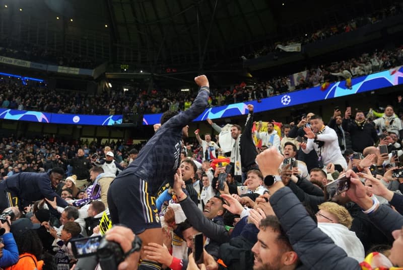 Real Madrid's Jude Bellingham (C) celebrates with fans following the UEFA Champions League quarter-final second leg soccer match between Manchester City and Real Madrid at the Etihad Stadium, Manchester. Martin Rickett/PA Wire/dpa