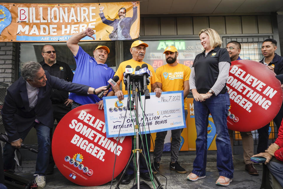 FILE - Business owner Joe Chahayed holds a check outside Joe's Service Center in Altadena, northeast of Los Angeles Tuesday, Nov. 8, 2022. His sons, Joe Chahayed, Jr., are at his left, and his son Daniel Chahayed, at his right. The winner of November's record-high $2.04 billion Powerball jackpot will soon be revealed in California. State lottery officials say the name of the person will be released during a Tuesday, Feb. 14, 2023 press conference in Sacramento. (AP Photo/Damian Dovarganes, File)