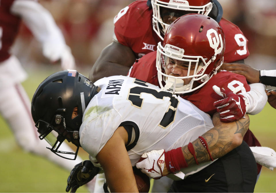 Oklahoma linebacker Curtis Bolton (18) tackles Army running back Darnell Woolfolk (33) in the first half of an NCAA college football game in Norman, Okla., Saturday, Sept. 22, 2018. (AP Photo/Sue Ogrocki)