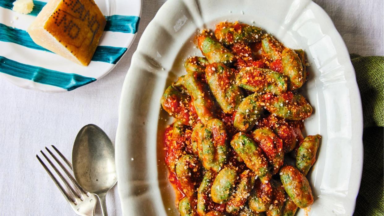  A photo of spinach gnocchi in tomato sauce. 