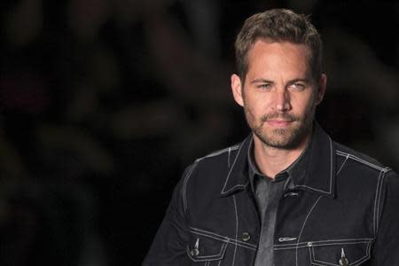 U.S. actor Paul Walker presents a creation from Colcci's 2013/2014 summer collection during Sao Paulo Fashion Week March 21, 2013. REUTERS/Filipe Carvalho/Files