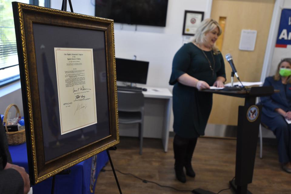A framed copy of legislation renaming the Middleburg VA Clinic as the Andrew K. Baker Department of Veterans Affairs Clinic was on display at the renaming ceremony. U.S. Rep. Kat Cammack is shown speaking in the background.