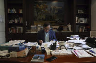 In this Aug. 20, 2019, photo, Huawei's founder Ren Zhengfei reads documents in his office at the Huawei campus in Shenzhen in Southern China's Guangdong province. Ren says its troubles with President Donald Trump are hardly the biggest crisis he has faced while working his way from rural poverty to the helm of China’s first global tech brand. (AP Photo/Ng Han Guan)