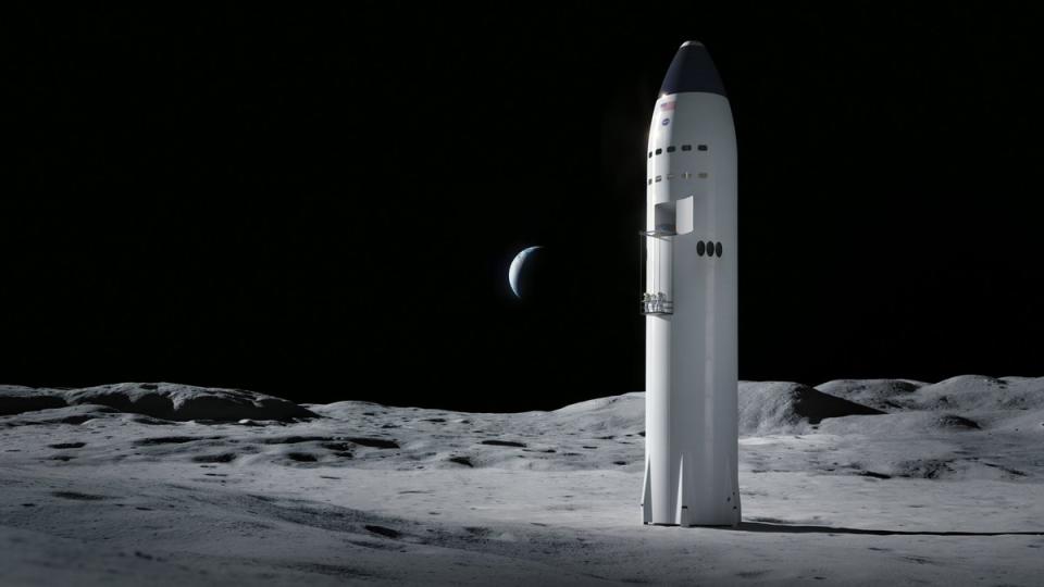 A large white rocket sits on the grey, cratered surface of the moon