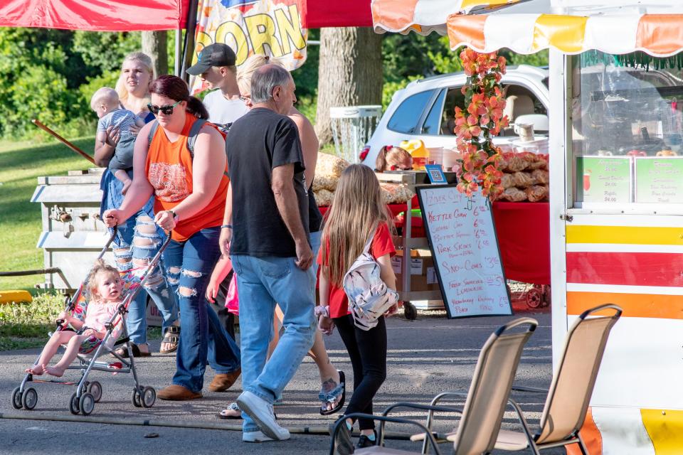 Crowds walk the paved roads of Byesville Park during the annual Firemen's Festival, deciding between fresh kettle corn or flavored daiquiris.