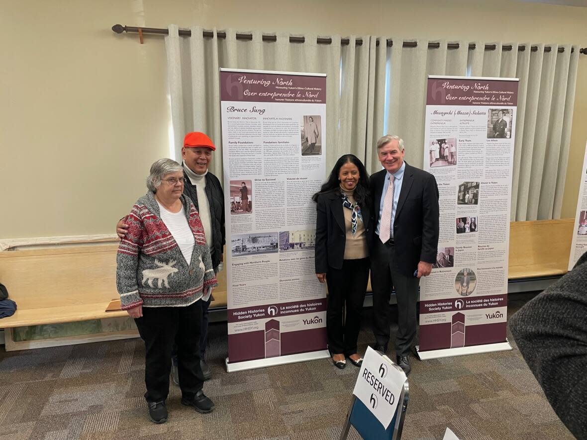 Bob Sung, second from the left, stands besides a panel about his father, Bruce Sung, a Chinese-Yukoner who opened the first supermarket in the territory. His story is on display at the  (Leonard Linklater/CBC - image credit)