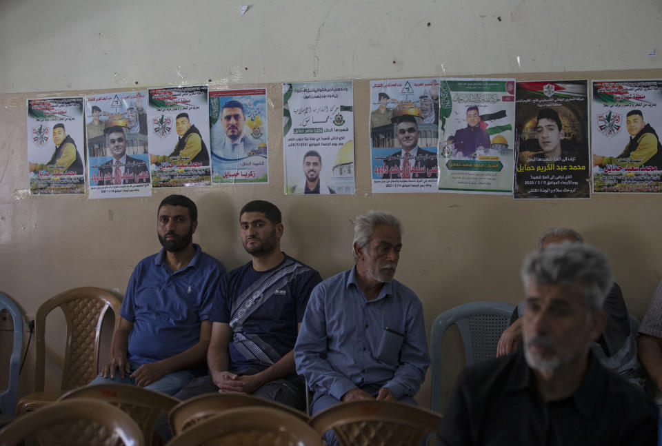 Mourners sit next to posters of 17-year-old Palestinian Mohammad Hamayel, in the village of Beita, south of the West Bank city of Nablus. Monday, June 14, 2021. Hamayel was killed during clashes with Israeli forces following a protest against the wildcat Jewish settlement of Eviatar that was established last month without the permission of Israeli authorities on land the Palestinians say is privately owned. (AP Photo/Majdi Mohammed)