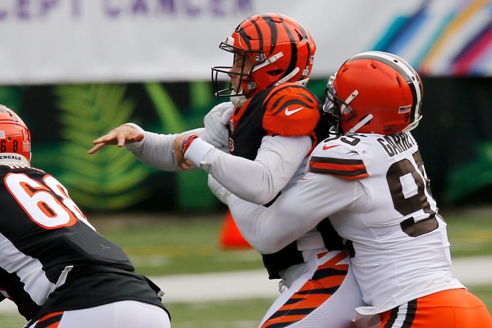 Cleveland Browns defensive end Myles Garrett (95) brings down Cincinnati Bengals quarterback Joe Burrow (9) as he throws the ball in the first quarter of the NFL Week 7 game between the Cincinnati Bengals and the Cleveland Browns at Paul Brown Stadium in downtown Cincinnati on Sunday, Oct. 25, 2020. The Bengals led 17-10 at halftime. 