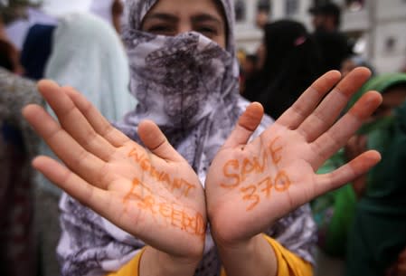 A Kashmiri woman shows her hands with messages at a protest in Srinagar