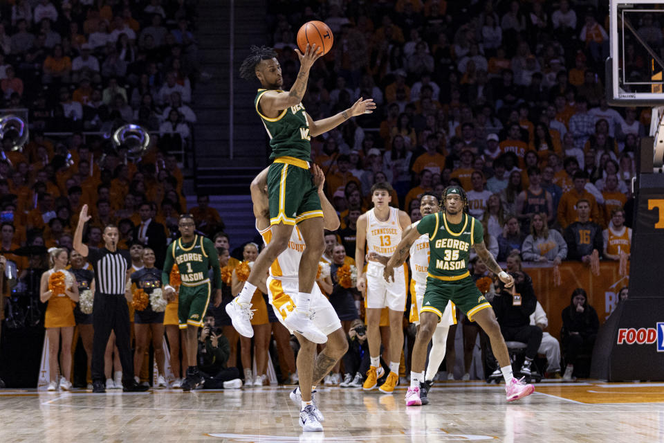 George Mason guard Ronald Polite III (1) catches an inbound pass in front of Tennessee guard Freddie Dilione V (1) during the first half of an NCAA college basketball game Tuesday, Dec. 5, 2023, in Knoxville, Tenn. (AP Photo/Wade Payne)
