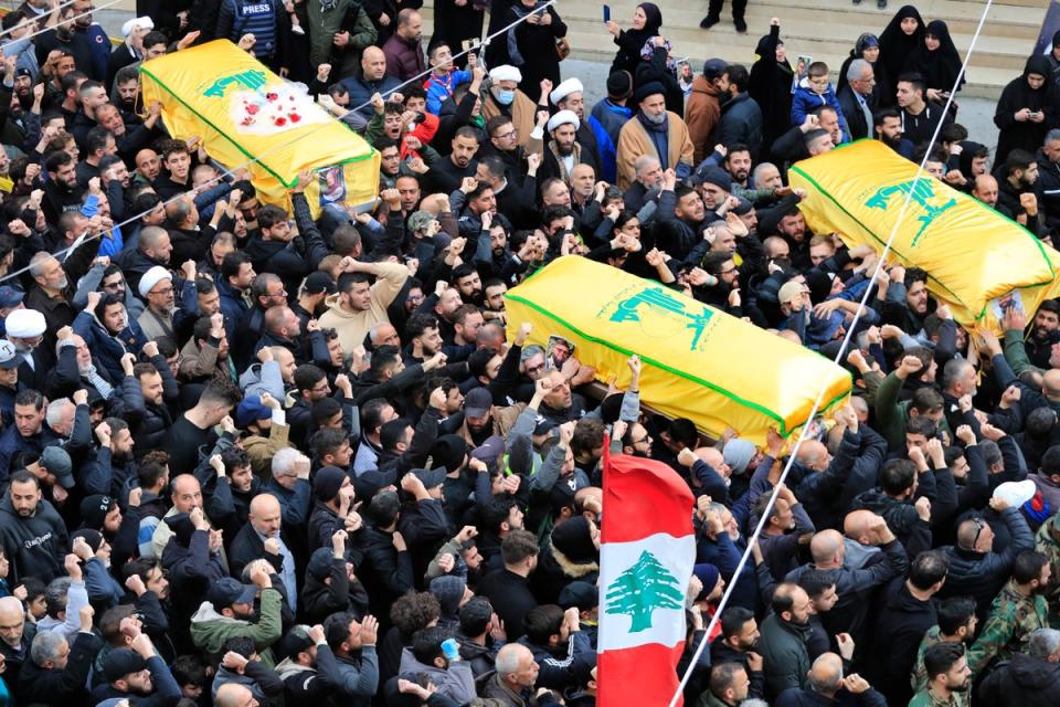 Mourners carry the coffins of a Hezbollah fighter and two civilians killed by an Israeli airstrike this week (AP)