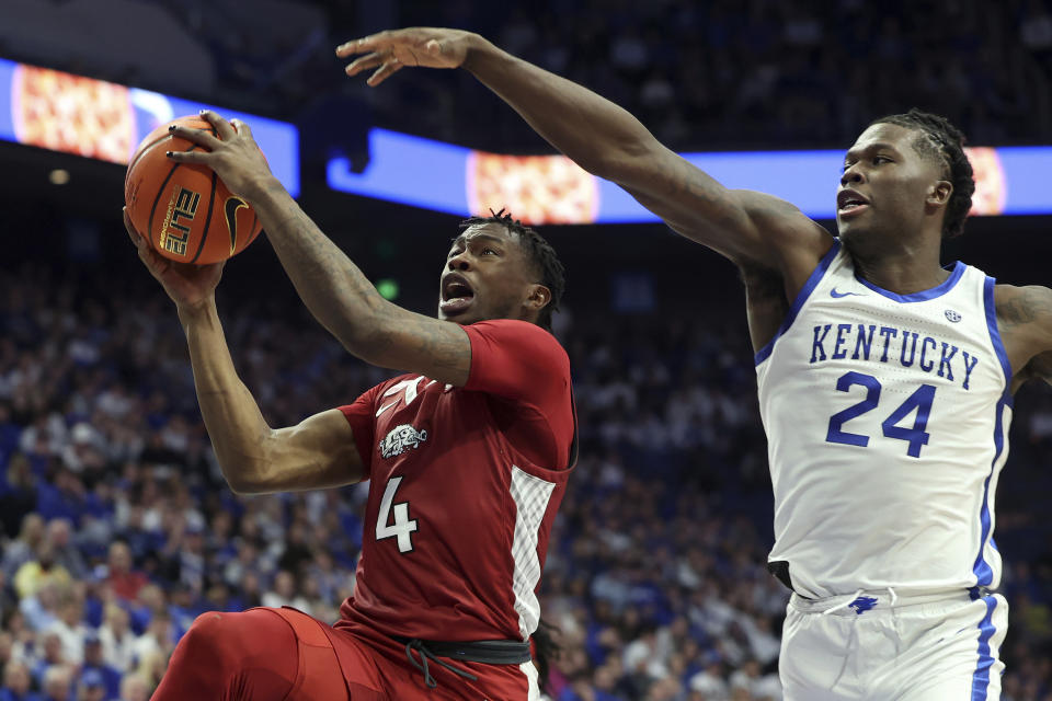 Arkansas' Davonte Davis (4) shoots while defended by Kentucky's Chris Livingston (24) during the second half of an NCAA college basketball game in Lexington, Ky., Tuesday, Feb. 7, 2023. Arkansas won 88-73, (AP Photo/James Crisp)