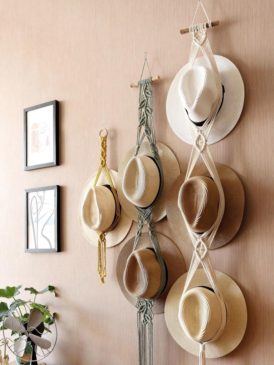 hats and macrame holders hanging from wall