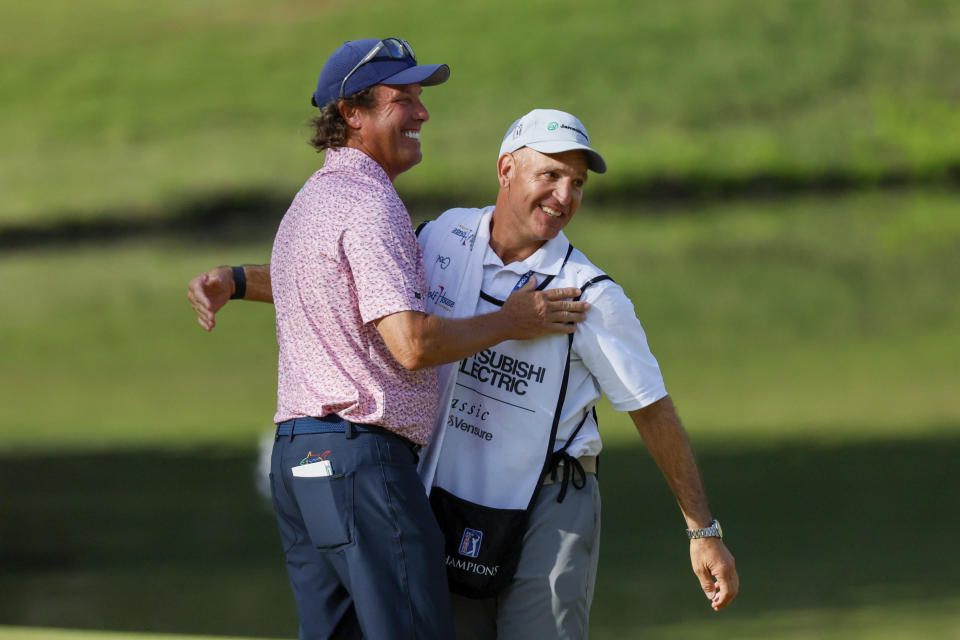 Stephen Ames celebrates with his caddie after making his putt on the 18th green on the 18th hole during the final round of the Mitsubishi Classic senior golf tournament at TPC Sugarloaf, Sunday, April 28, 2024, in Duluth, Ga. (Miguel Martinez/Atlanta Journal-Constitution via AP)