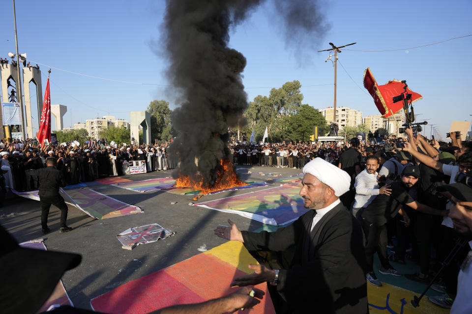 Supporters of Shiite Muslim leader Moqtada Sadr burn a rainbow flag, during a demonstration in front of the Swedish embassy in Baghdad in response to the burning of Quran in Sweden, Baghdad, Iraq, Friday, June 30, 2023. (AP Photo/Hadi Mizban)