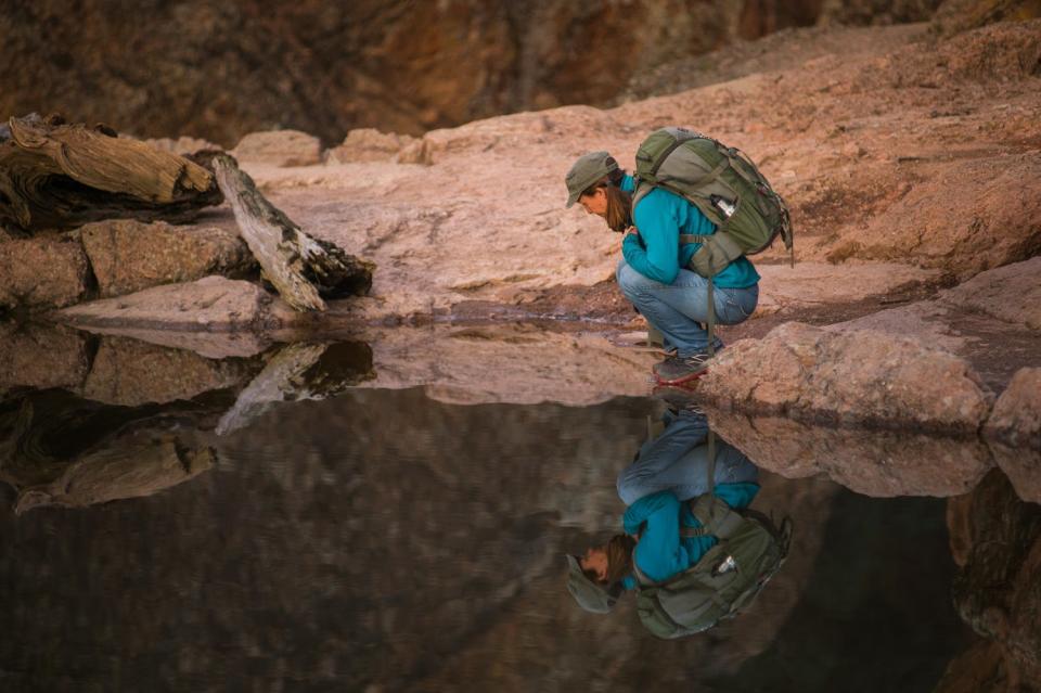 A visitor is reflected in Bear Gulch Reservoir in Pinnacles National Park.