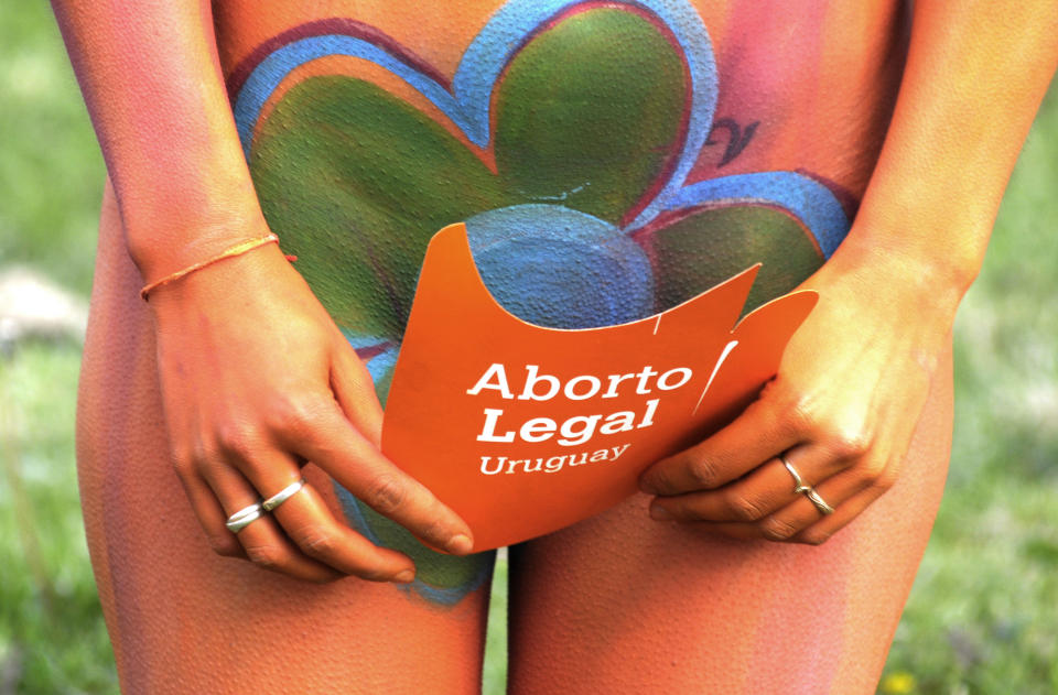 A pro abortion activist, with her body painted, demonstrates in front of the Uruguayan congress in Montevideo, Uruguay, Tuesday, Sept. 25, 2012. Uruguay's congress appeared ready on Tuesday to legalize abortion, a groundbreaking move in Latin America, where no country save Cuba has made abortions accessible to all women during the first trimester of pregnancy. The sign reads in Spanish "legal abortion." (AP Photo/Matilde Campodonico)