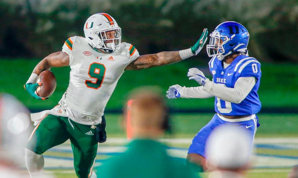 Miami Hurricanes tight end Brevin Jordan (9) carries the football as Duke Blue Devils safety Marquis Waters (0) closes in the first half at Wallace Wade Stadium Saturday, Dec. 5, 2020.