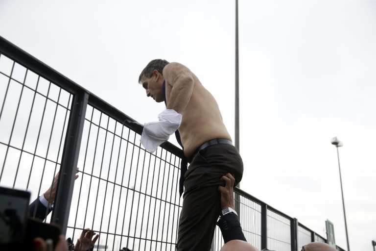 Human resources director Xavier Broseta, shirtless, tries to cross a fence after several hundred employees disrupted a meeting at the offices of Air France on October 5, 2015