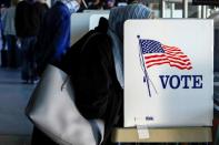 A voter fills out her ballot during early voting at ONEOK Field in Tulsa