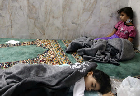 FILE PHOTO: Girls who survived, from what activists say is a gas attack, rests inside a mosque in the Duma neighbourhood of Damascus, Syria August 21, 2013. REUTERS/Mohamed Abdullah/File Photo