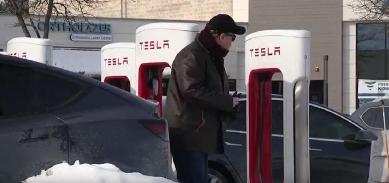 A man at a Tesla charging station in Illinois