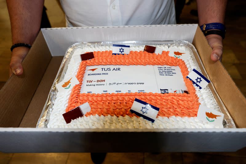 A man holds a cake decorated as a boarding pass, marking the first direct commercial flight between Israel and Qatar for the 2022 FIFA World Cup Qatar, at Ben Gurion International Airport, near Tel Aviv