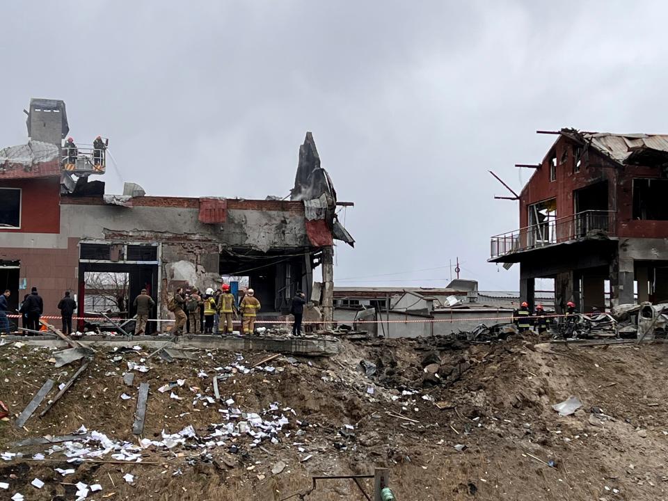 Emergency workers clear up debris after an airstrike hit a tire shop in the western city of Lviv, Ukraine, on Monday.