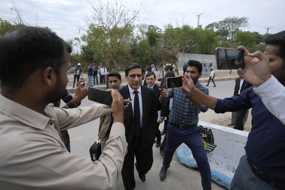 Khawaja Haris, center, lawyer of Pakistan's former Prime Minister Imran Khan, is surrounded by members of media as he arrives to appear in court, in Islamabad, Pakistan, Tuesday, May 23, 2023. Khan on Tuesday pressed his legal battle before a court in the capital, Islamabad, which granted him protection from arrest until early next month in several cases where he faces terrorism charges for inciting violence. (AP Photo/Anjum Naveed)