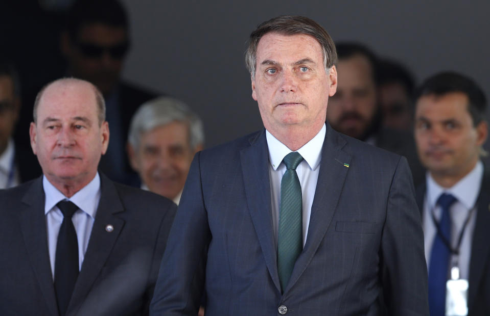 Brazil's President Jair Bolsonaro, right, and his Defense Minister Fernando Azevedo leave after meeting with military commanders at the Defense Ministry in Brasilia, Brazil, Tuesday, Jan. 7, 2020. Bolsonaro spoke about maintaining commercial ties with Iran this morning, said he would speak to his foreign minister about talks with Iran, and reiterated that Brazil opposes terrorism. (AP Photo/Eraldo Peres)