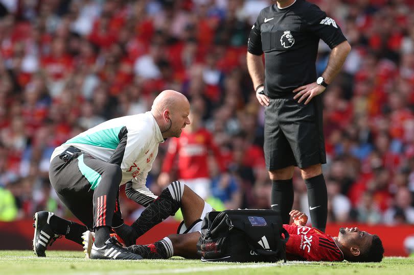 Amad is treated after his Manchester United penalty appeal was turned down