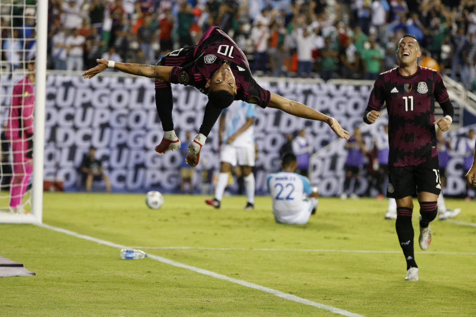 Mexico midfielder Orbelin Pineda (10) does a flip after scoring a goal against Guatemala as forward Rogelio Funes Mori (11) looks on during the second half of a CONCACAF Gold Cup Group A soccer match in Dallas, Wednesday, July 14, 2021. (AP Photo/Michael Ainsworth)