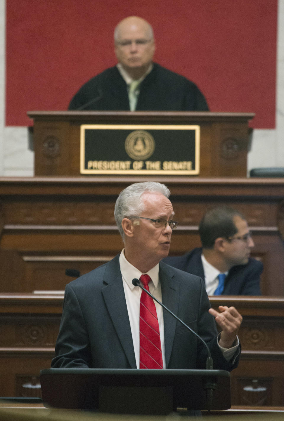 Judge Paul Farrell, top, presides over the Senate as House manager, John Shott, R-Mercer, addresses the Senate during a pre-trial impeachment conference for four Supreme Court justices in the West Virginia State Senate chambers at the Capitol in Charleston, W,Va., Tuesday, Sept. 11, 2018. (AP Photo/Steve Helber)