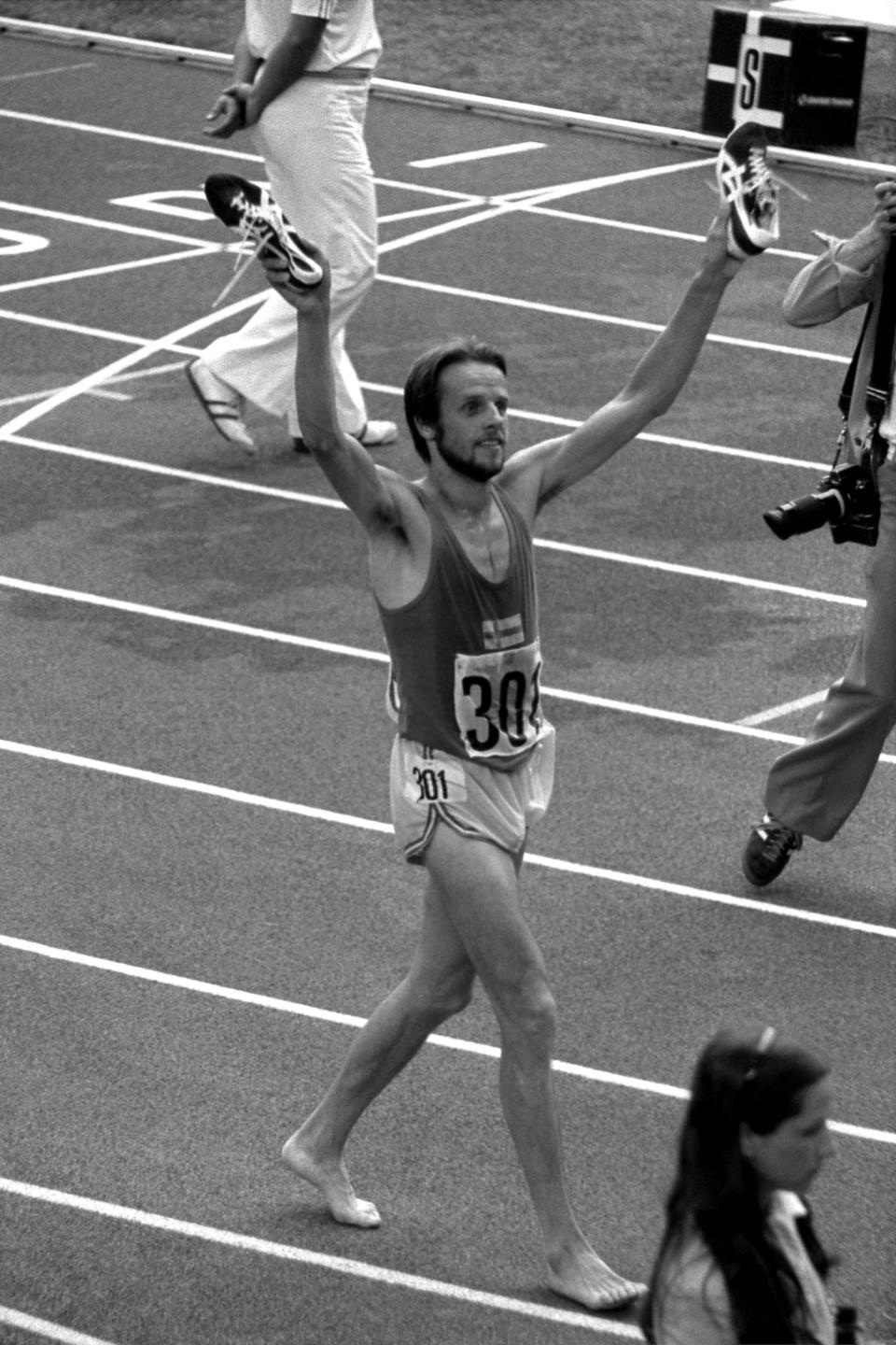 Lasse Viren brandit ses chaussures après sa victoire sur 10 000 mètres aux JO de Montréal en 1976 (Crédit : S&G/PA Images via Getty Images)