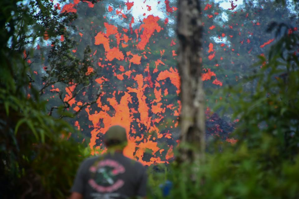 <p>A man watches as lava is seen coming from a fissure in Leilani Estates subdivision on Hawaii’s Big Island on May 4, 2018. (Photo: Frederic J. Brown/AFP/Getty Images) </p>