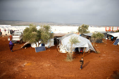 Displaced Syrian children stand outside of their tents at Kelbit refugee camp, near the Syrian-Turkish border, in Idlib province, Syria January 17, 2018. REUTERS/Osman Orsal