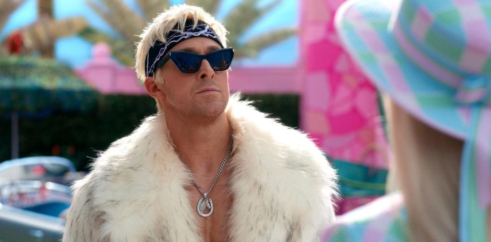 Ryan Gosling is dressed as Ken in black sunglasses, a bandana, and a white fur coat as part of a scene of the "Barbie" movie.