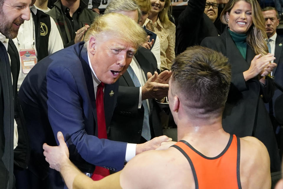 Former President Donald J. Trump, left congratulates Princeton wrestler Pat Glory, right, after Glory won the NCAA Wrestling Championship at the 125 lb class, Saturday, March 18, 2023, in Tulsa, Okla. (AP Photo/Sue Ogrocki)