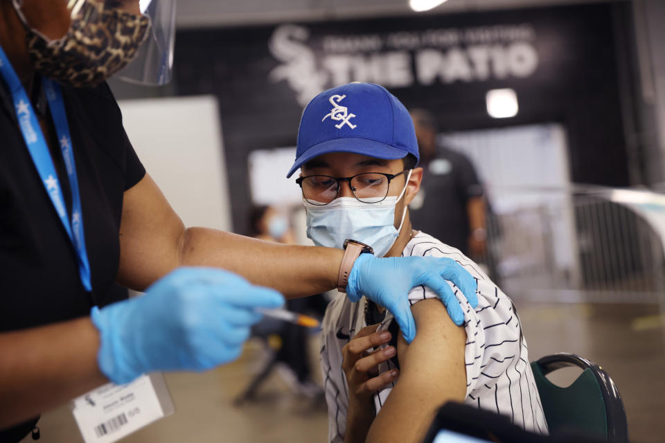 CHICAGO, ILLINOIS - JUNE 08: Christian Santos receives a COVID-19 vaccine at Guaranteed Rate Field before the start of the Chicago White Sox game against the Toronto Blue Jays on June 08, 2021 in Chicago, Illinois. Fans who received the vaccine were offered two free tickets to the game or received a voucher good for two tickets to a future game. (Photo by Scott Olson/Getty Images)