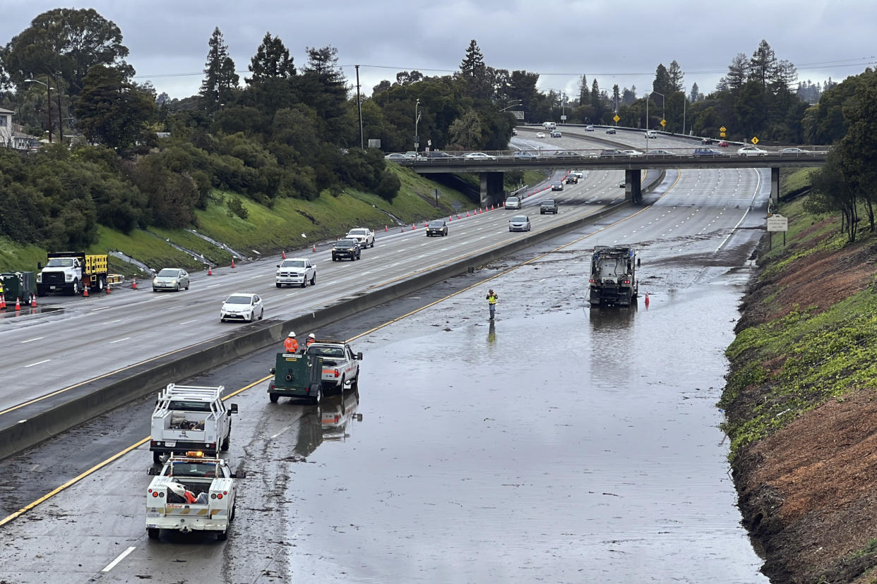 Caltrans crews work by a flooded section of Interstate 580 in Oakland, Calif., Friday, March 10, 2023. A new atmospheric river has brought heavy rain and thunderstorms to California, bringing flood threats and disrupting travel. (AP Photo/Terry Chea)