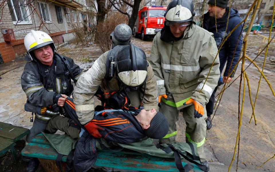 Firefighters carry an elderly man out of an apartment building damaged by recent shelling in the course of Russia-Ukraine conflict in Donetsk, Russian-controlled Ukraine