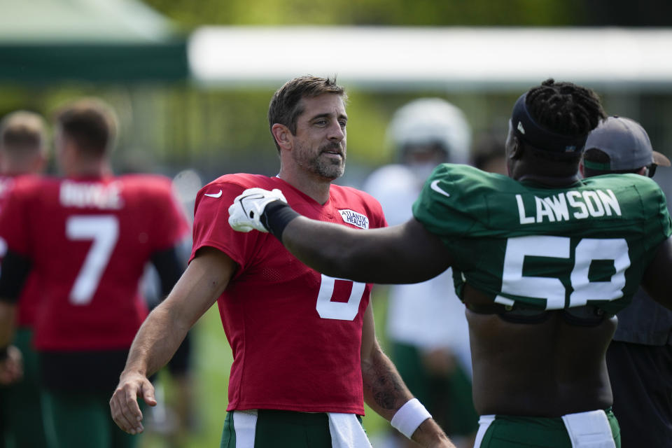 New York Jets quarterback Aaron Rodgers, left, greets Carl Lawson during a practice session at the NFL football team's training facility in Florham Park, N.J., Sunday, July 30, 2023. (AP Photo/Seth Wenig)
