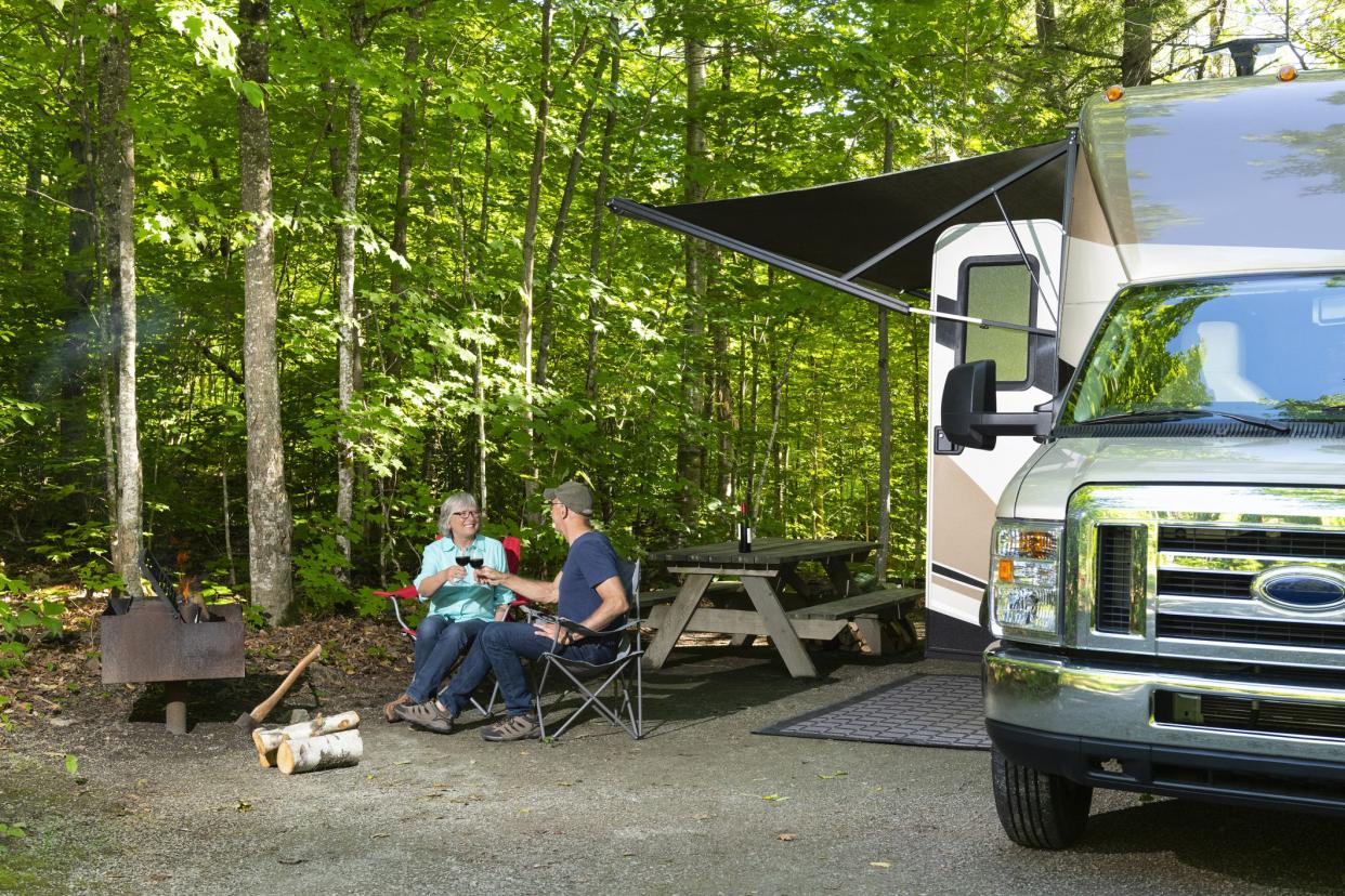 couple relaxing under shade outside rv