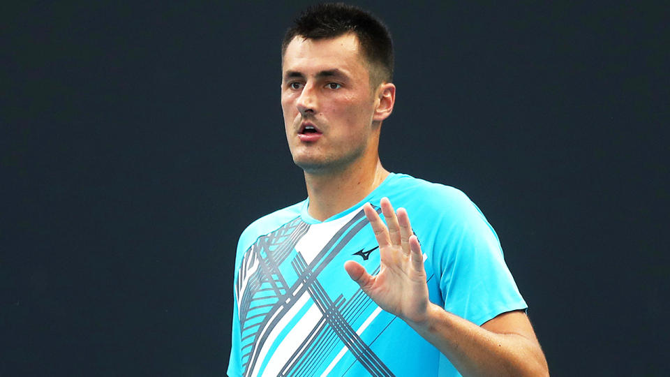 Bernard Tomic (pictured) raising his hand during Round 1 at the Australian Open.