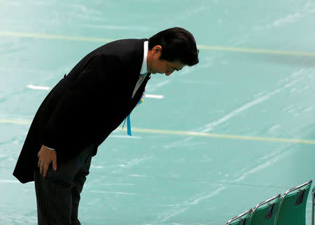 Japan's Prime Minister Shinzo Abe bows to attendants as he arrives at a memorial ceremony marking the 72nd anniversary of Japan's surrender in World War Two, at Budokan Hall in Tokyo, Japan August 15, 2017. REUTERS/Kim Kyung-Hoon