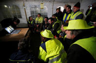 Protesters wearing yellow vests watch French President Emmanuel Macron on a computer screen in Sainte-Eulalie, France, December 10, 2018. REUTERS/Regis Duvignau