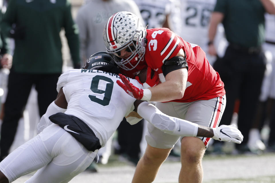 Michigan State defensive back Ronald Williams, left, tackles Ohio State tight end Mitch Rossi during the first half of an NCAA college football game Saturday, Nov. 20, 2021, in Columbus, Ohio. (AP Photo/Jay LaPrete)