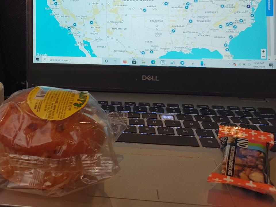 train seat-back tray filled will a laptop, a radio, and some packaged snacks on the amtrak