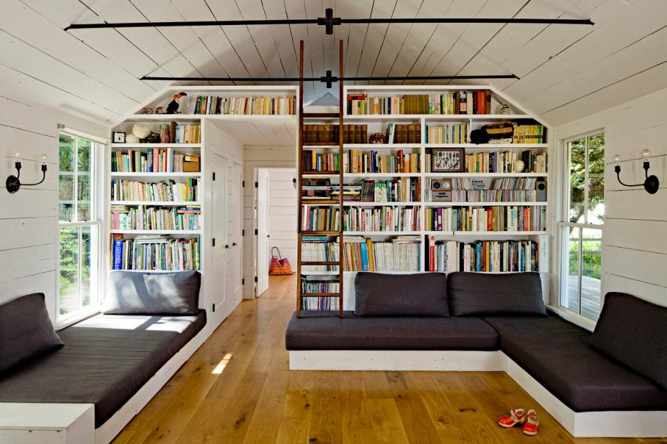 The other side of the great room comprises the living room and a ladder to the loft. That space features bookcases designed and built by Doulis with the help of an architect friend.