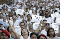 FILE - In this Feb. 1, 2019 file photo, friends and relatives hold signs with the names of victims, during a march paying homage to the victims of a mining dam collapse one week prior in Brumadinho, Brazil. The wave of mud and debris that on Jan. 25, 2019 buried the equivalent of 300 soccer pitches and killed 270 people, continues to barrel over residents’ minds, the local economy and the environment, one year later. (AP Photo/Andre Penner, File)